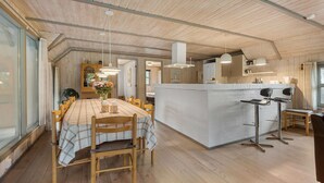 A spacious kitchen with wooden flooring, a central island, and pendant lighting. - Nice home in Blåvand with sauna (Blåvand)