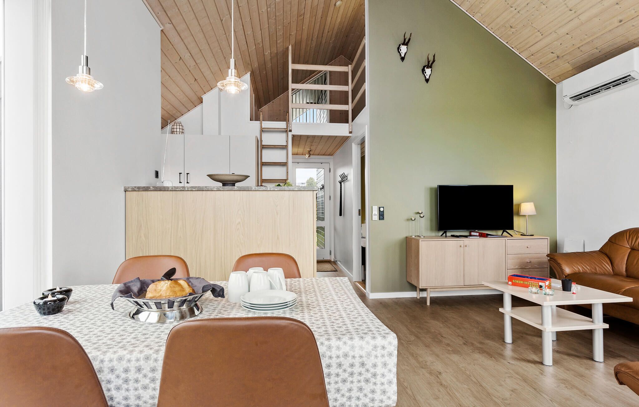 A modern living space with a dining area, kitchen, and a cozy seating area.