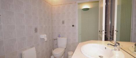 Un baño con inodoro, lavabo y bidé.