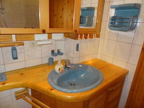 A bathroom with a wooden vanity, a blue sink, and a mirror above it. - Heidelberg, 2 BR, EC, 52m² - Heidelberg, Viola (Neustadt in Holstein)