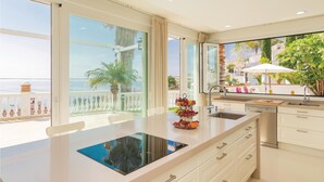 A modern kitchen with a large island, a sink, and a view of the sea. - Nice home in Almuñecar (Almuñecar)