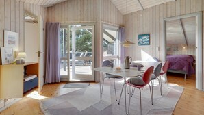 Een gezellige kamer met een eethoek, een bed en een groot raam.
