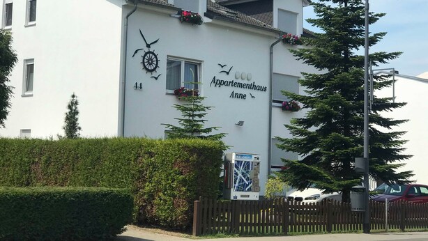 Ein Gebäude mit einem Schild, auf dem „Appartementhaus Anne“ steht, und der Hausnummer 44 an der Wand.