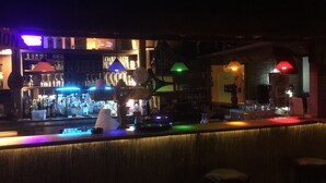 Zona de bar con mostrador, taburetes y diverso equipo.