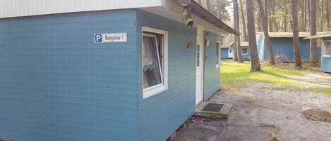 A blue mobile home with a parking sign labeled "Burgalow-1".