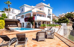 A two-story building with a swimming pool, outdoor seating, and a balcony. - Nice home in Riviera del Sol (Riviera del Sol)