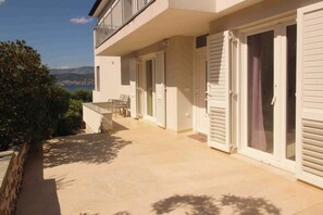 Relax on the balcony with a table and chairs, taking in the scenic views of the surrounding greenery and distant mountains.