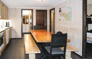 A compact kitchen with wooden cabinets, a wooden dining table, and a bench. - Gorgeous apartment in Hemsedal (Hemsedal)