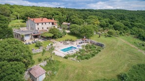A large stone house with a red roof, surrounded by lush greenery and a swimming pool. - 3 bedroom stunning home in Gora Glusic (Gora Glusic)
