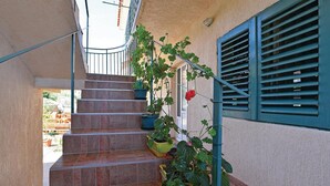 A staircase with potted plants and a window with blue shutters. - Awesome apartment in Raslina with WiFi (Raslina)