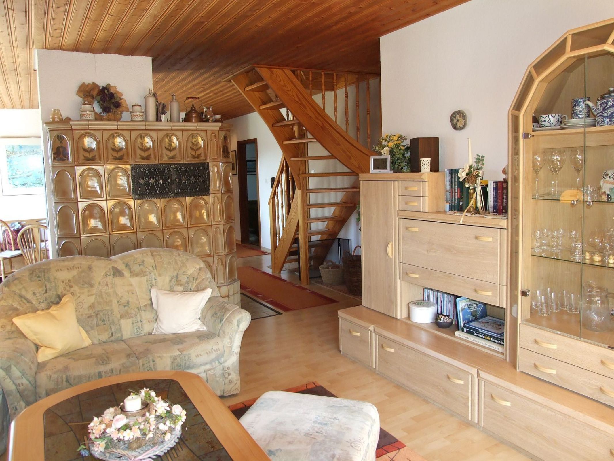 A cozy living room with a sofa, a coffee table, and a staircase leading to an upper level.
