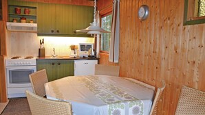 A cozy kitchen with a stove, sink, and a dining area with a table and chairs. - 3 bedroom stunning home in Kirke Hyllinge (Kirke Hyllinge)