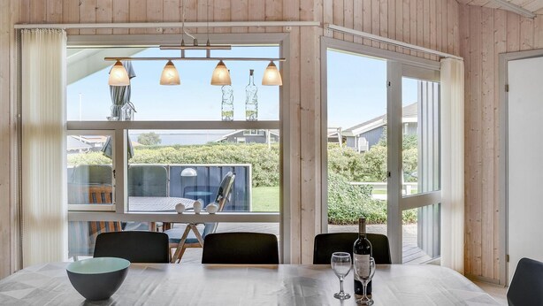Un comedor con mesa, sillas y vistas al exterior.