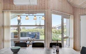Un espace repas comprenant une table, des chaises et une vue sur l’extérieur.