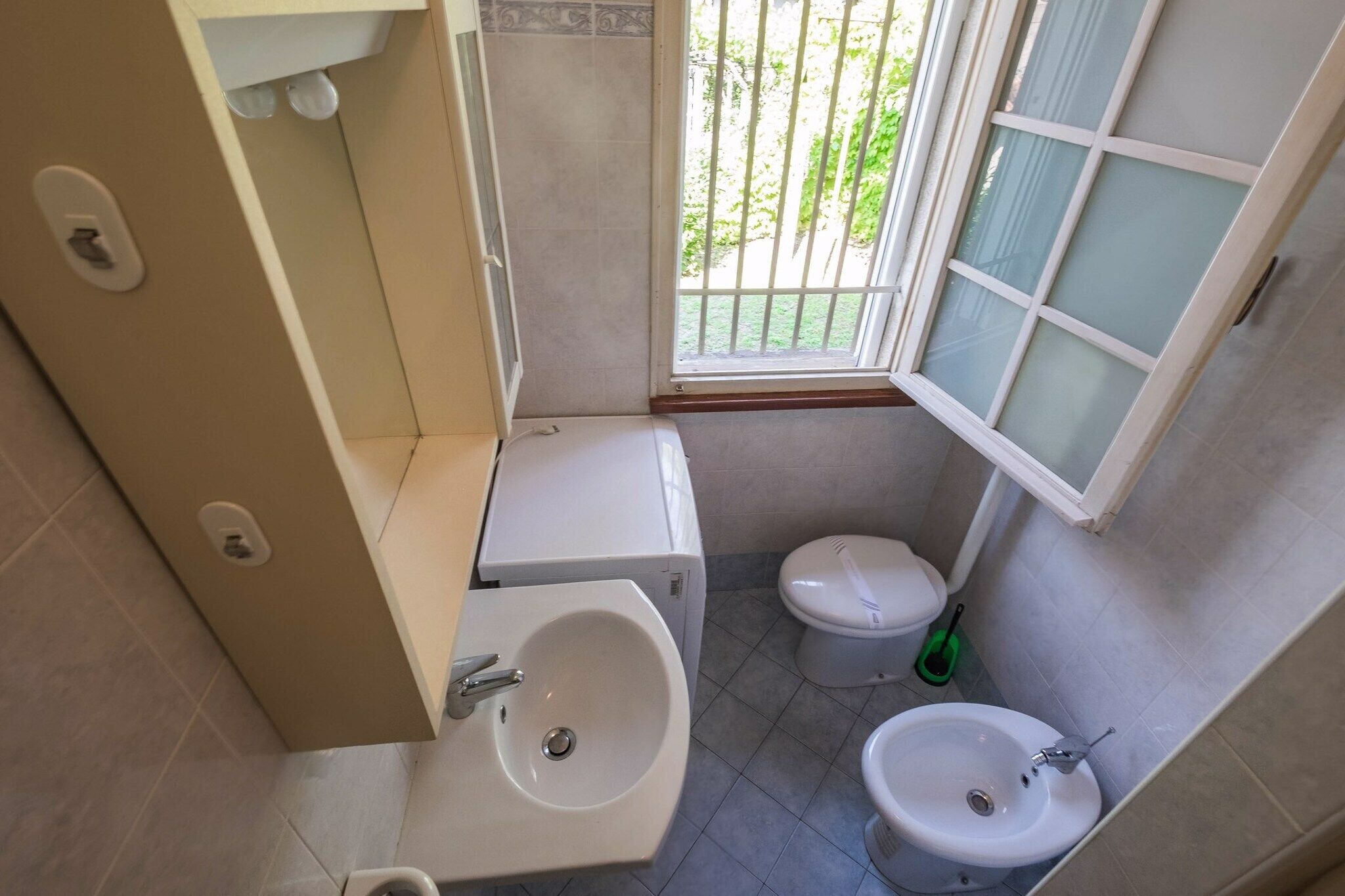 A small bathroom with a toilet, bidet, and sink.