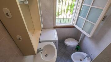 A small bathroom with a toilet, bidet, and sink.