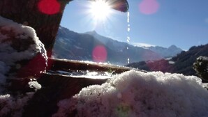 Un paysage de montagne avec un ciel dégagé et une cascade.