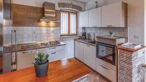 Una cucina moderna con piano cottura a gas, forno e parete in mattoni.
