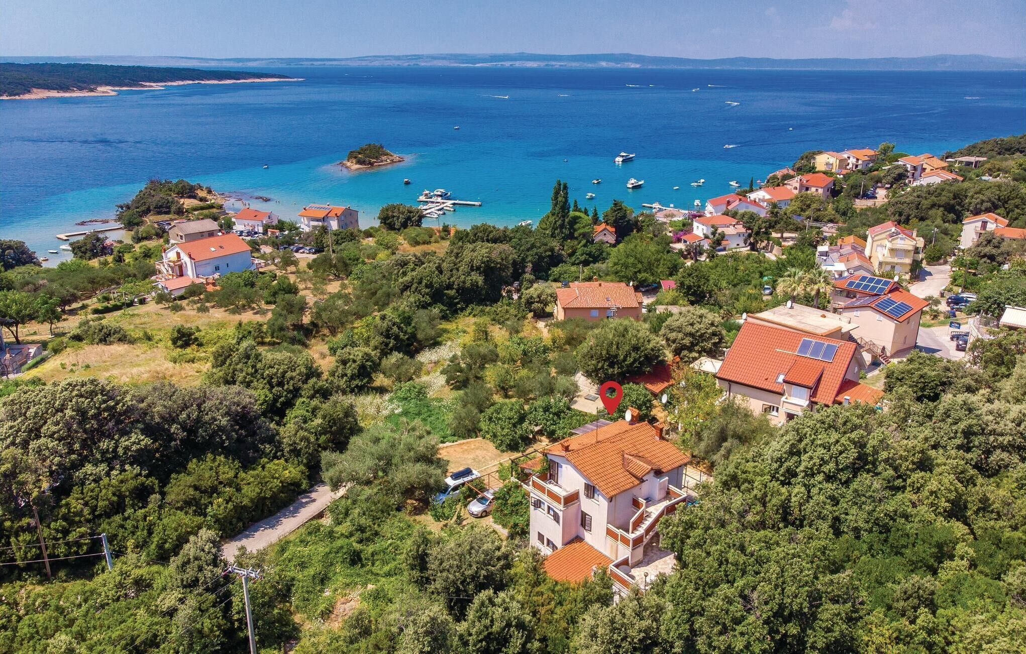 A coastal village with houses, a marina, and boats.