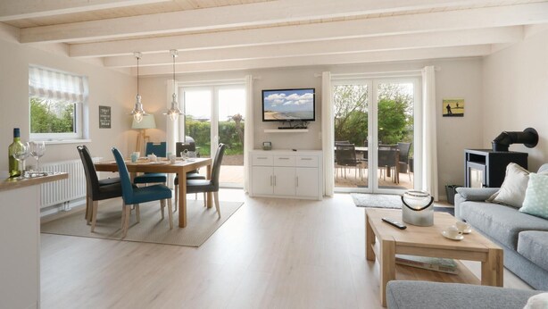 A spacious living area with a dining table, chairs, a sofa, and a television. - Gorgeous home in Süssau/Ostsee with sauna (Süssau/Ostsee)