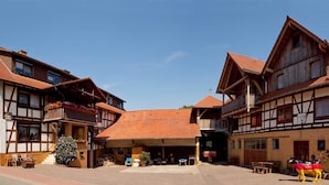 A traditional European building with a central courtyard, featuring a covered seating area and a small Christmas tree. - HIMME - Farmhouse Büchsenschütz (Vöhl)