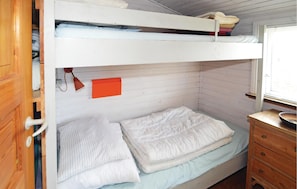 A bunk bed room with a wooden wardrobe, a small table with a bowl, and a window with blinds. - 3 bedroom beach front home in Hjørring (Hjørring)