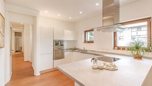 Una cocina moderna con una isla central, electrodomésticos de acero inoxidable y un ventanal con vistas.