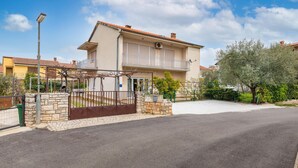 A two-story residential building with a stone facade, a balcony, and a gated entrance. - 3 bedroom nice apartment in Fazana (Fazana)