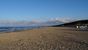 A beach with a sandy shore, a few people, and beach huts numbered 128 and 130. - House Lachmöwe Karl Hagen on Usedom - House Lachmöwe (Karlshagen)