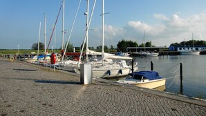 A marina with several sailboats docked along a cobblestone waterfront. - House Lachmöwe Karl Hagen on Usedom - House Lachmöwe (Karlshagen)