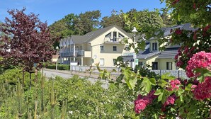 A residential area with houses, a balcony, and lush greenery.