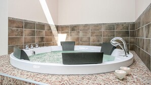 A modern bathroom with a freestanding bathtub, a large mirror, and a tiled backsplash. - Amazing home in Idestrup with sauna (Idestrup)