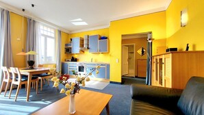 A compact living space with a dining area, a sofa, and a kitchenette. - (165) 2-room apartment - apartment house Sonnenresidenz I (Kühlungsborn)