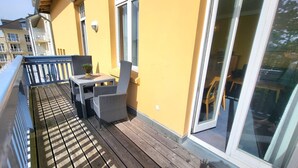 A balcony with wicker furniture, a small table, and a potted plant. - (165) 2-room apartment - apartment house Sonnenresidenz I (Kühlungsborn)