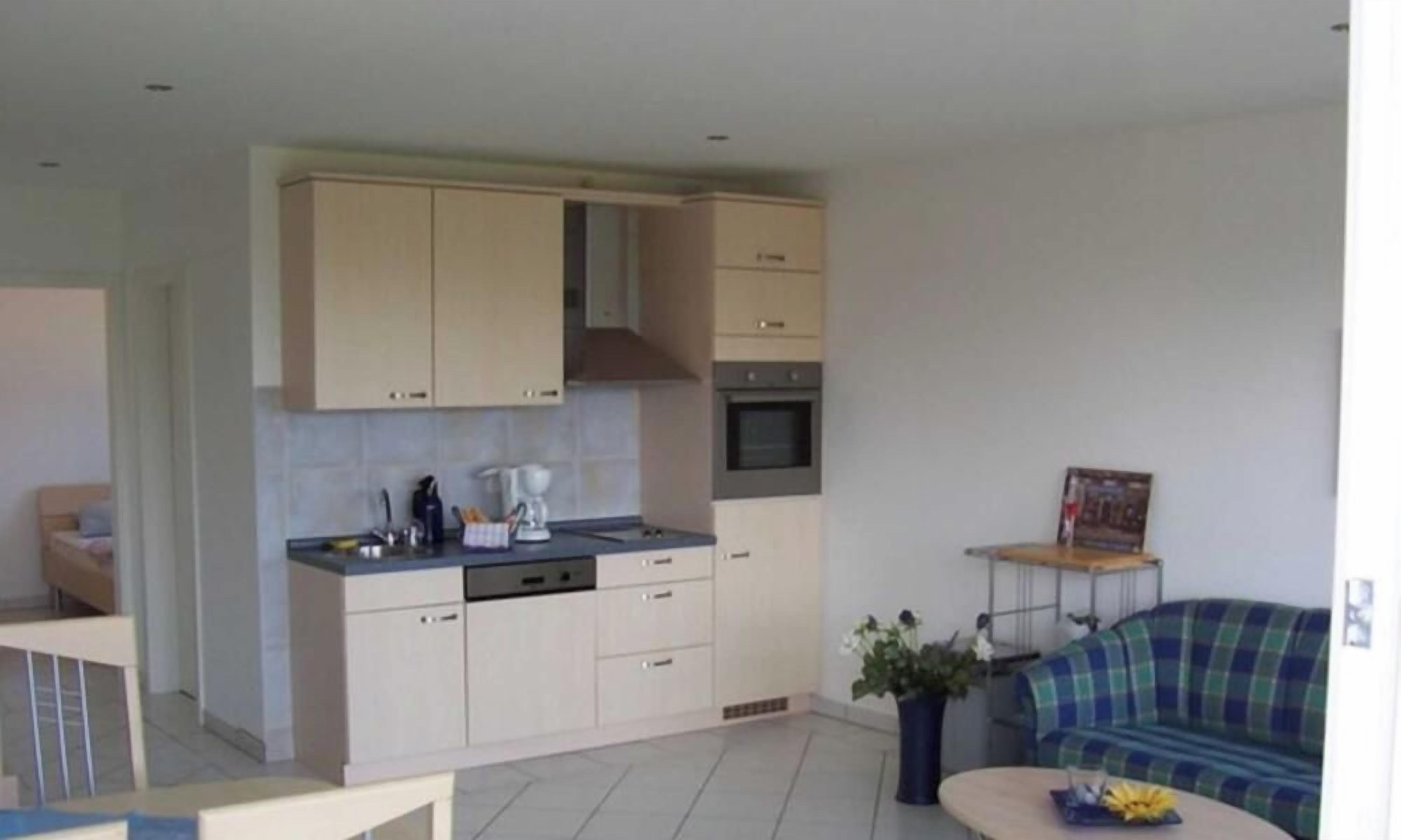A compact living space with a kitchenette, a sofa, and a small dining area.