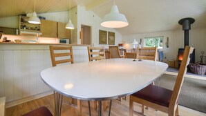 A modern kitchen with wooden cabinets, a white island, and pendant lighting. - Lovely home in Ebeltoft with sauna (Ebeltoft)