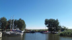 A marina with several boats docked, surrounded by trees and calm water.