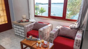 Ein gemütliches Zimmer mit einem roten Sofa und einem kleinen Holztisch mit Getränken und Snacks.