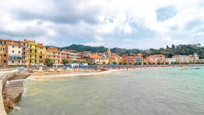 Une ville côtière aux bâtiments aux couleurs vives, avec une plage et un ciel dégagé.