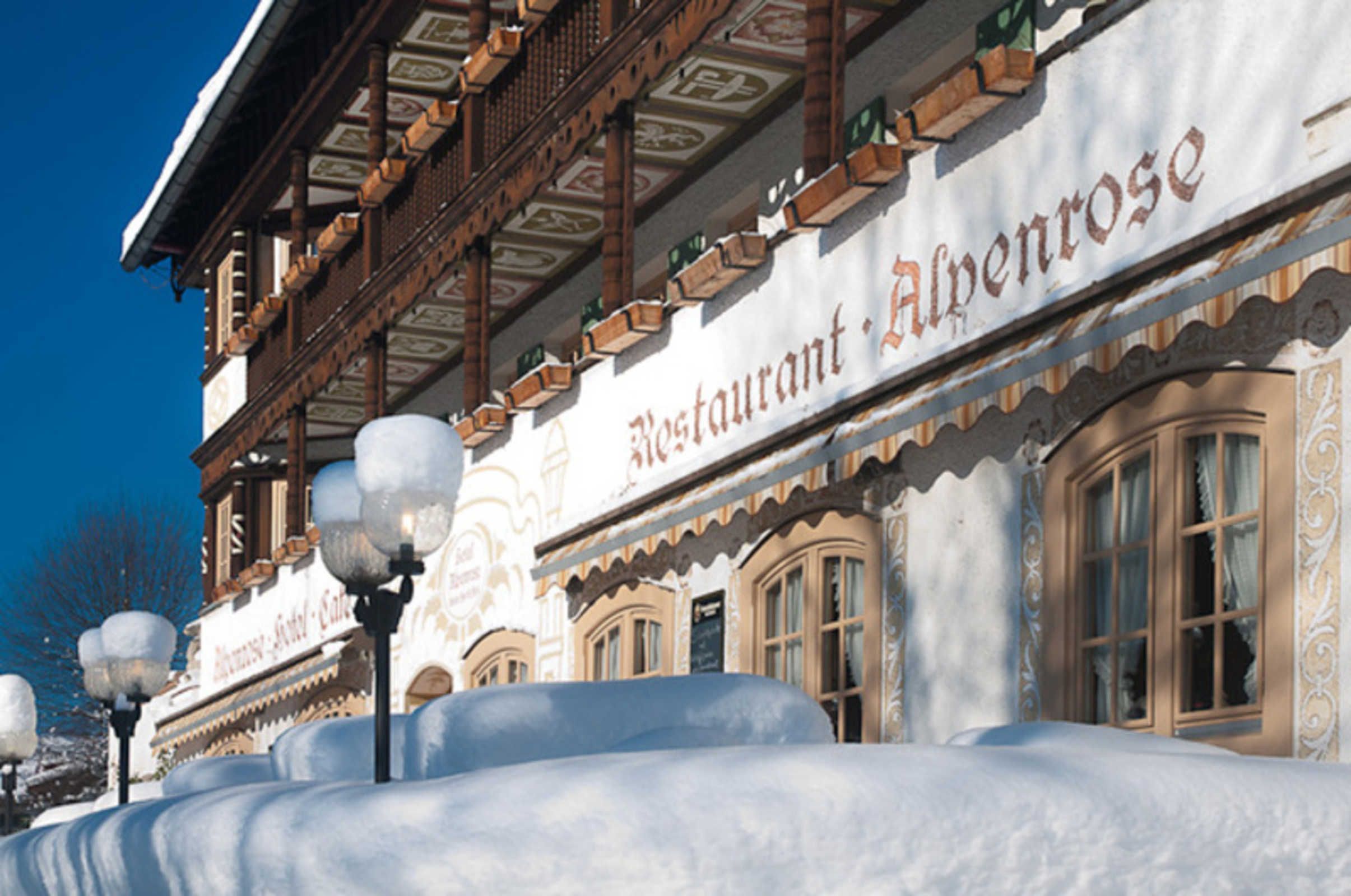 En traditionell byggnad med en skylt som visar texten ”Restaurang Alpenrose”.