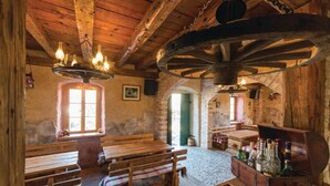 Un intérieur rustique avec des bancs en bois, une table en bois et un buffet en bois contenant des bouteilles.