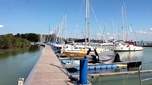 Een jachthaven met meerdere zeilboten aan een houten steiger.