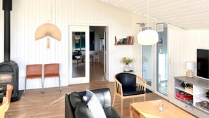 Ein modernes Wohnzimmer mit Kamin, Ledersofa, Holztisch und Bücherregal.