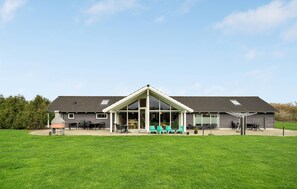 A two-story building with a large glass front and a covered patio area. - Awesome home in Idestrup with sauna (Idestrup)
