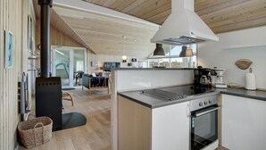 Eine moderne Küche mit Backofen, einer Kaffeemaschine und einem großen Fenster.