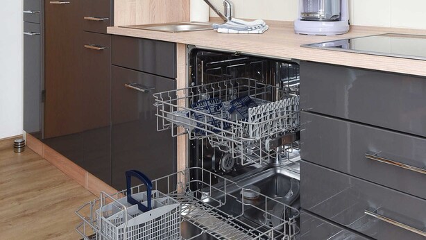 Een moderne keuken met een vaatwasser, een ingebouwde oven en een koffiezetapparaat op het aanrecht.