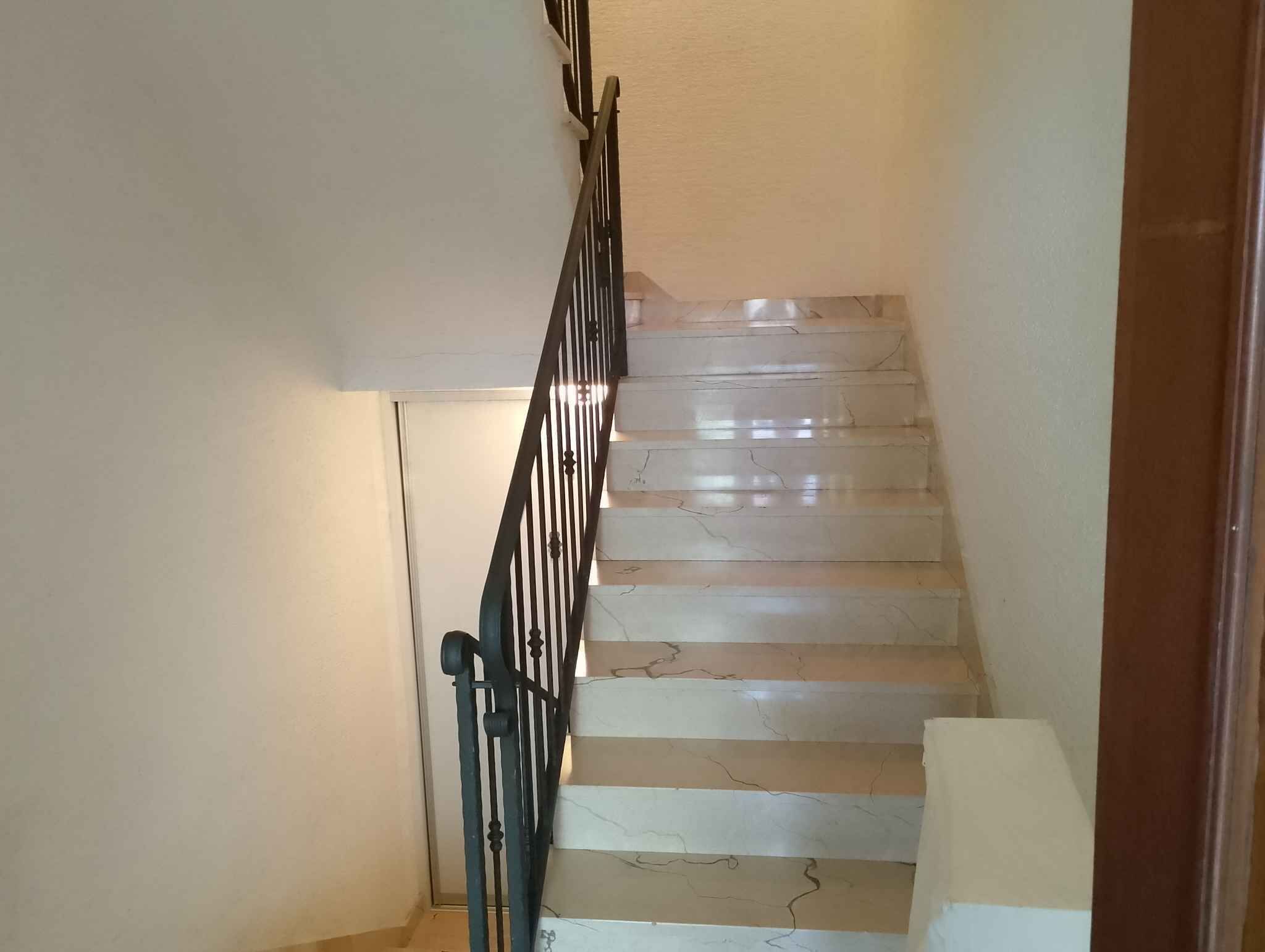 Eine Treppe mit Metallgeländer und Marmorstufen.