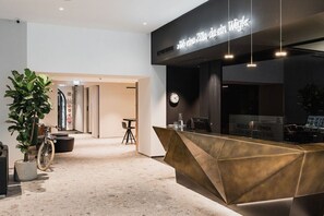 Un comptoir d’accueil au design moderne, une horloge et une enseigne au-dessus du comptoir.