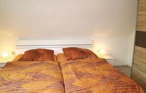 A double bed with striped bedding in a hotel room. - Pet friendly apartment in Schleusingen (Schleusingen)