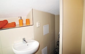 A bathroom with a white sink, a mirror, and orange towel dispensers. - Pet friendly apartment in Schleusingen (Schleusingen)